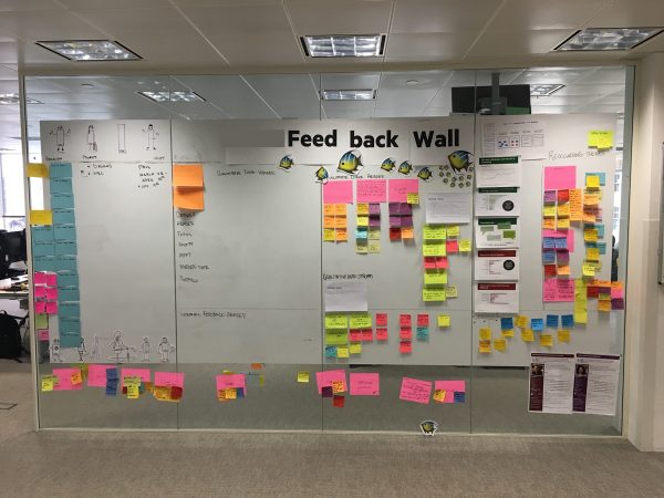 A photo of the feedback wall covered in post it notes