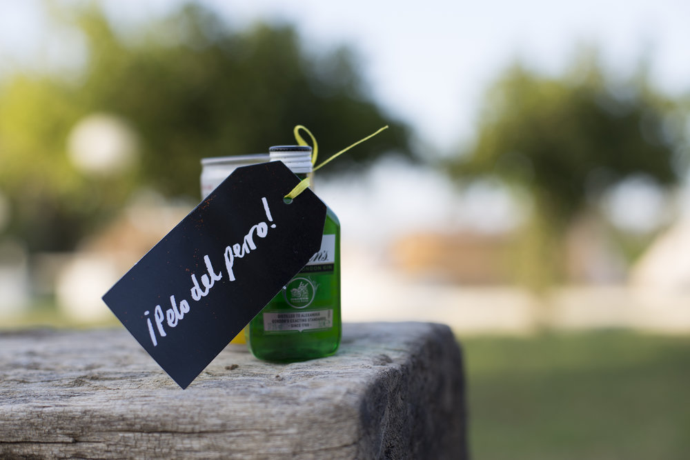 A bottle with a black and white tag attached with yellow ribbon further connecting to branding