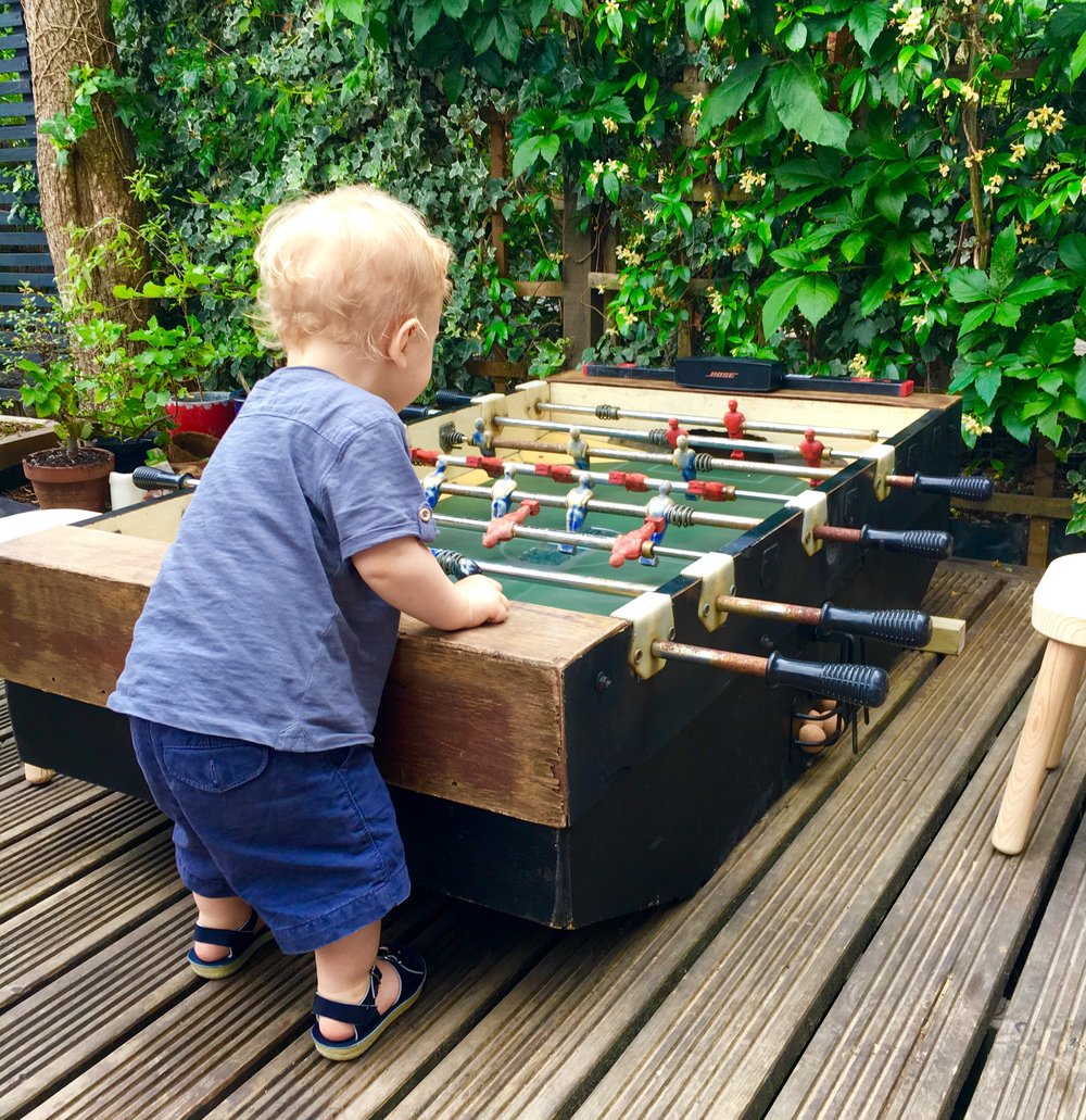 Andreas youngest playing with a mini foosball table