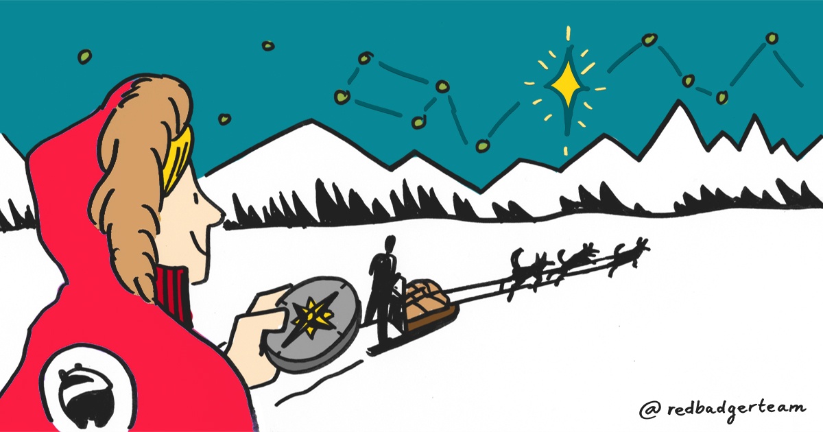 Woman in a Red Badger branded coat holding a compass and looking on to a sleigh surrounded by stars and mountains